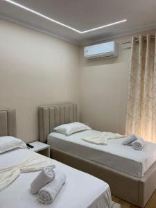um quarto com duas camas com toalhas em Vila Qyteza em Korçë
