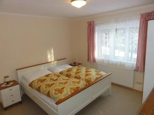 ein Schlafzimmer mit einem Bett mit einer gelben und weißen Decke in der Unterkunft Ferienhaus Reith in Bad Mitterndorf