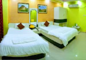 Hotel Gitanjali Malda tesisinde bir odada yatak veya yataklar