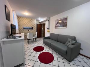 - un salon avec un canapé et un tapis rouge dans l'établissement Gold Experience, à Bolzano