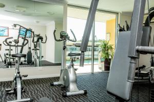 un gimnasio con máquinas de correr y espejo en Hotel Gloria, en Springwood