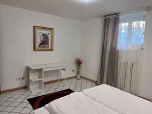 - une chambre avec un lit, un bureau et une fenêtre dans l'établissement Gold Experience, à Bolzano