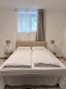 - un grand lit blanc dans une chambre avec fenêtre dans l'établissement Gold Experience, à Bolzano