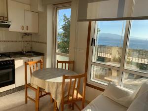 a kitchen with a table and chairs in front of a window at Hotel Playa in Cangas de Morrazo