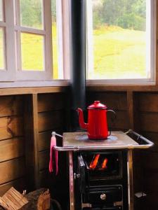 a red pot sitting on top of an oven at Casa na árvore perto da praia in Imaruí