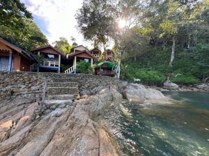 ein Haus mit einem Fluss davor in der Unterkunft Mama's Bungalows Koh Chang Ranong in Koh Chang Ranong