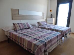 1 dormitorio con 2 camas y ventana en El sauce, en Lerma