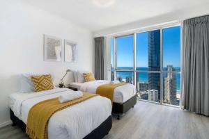 a hotel room with two beds and a large window at 3 Bedroom Apartment with Ocean Views in Central Location - Chevron Renaissance - Wow Stay in Gold Coast