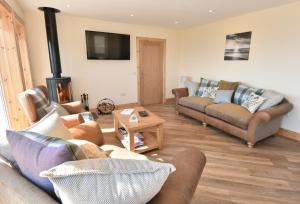 a living room with two couches and a fireplace at Rockpool in Pollachar