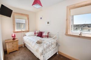 a bedroom with a bed and a window at Rockpool in Pollachar