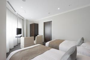 a hotel room with two beds and a television at Palace Hotel Omiya in Saitama