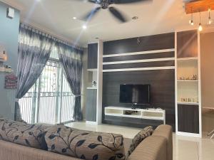 a living room with a couch and a flat screen tv at Art Homestay 4 Bedrooms House by Mr Homestay in Teluk Intan