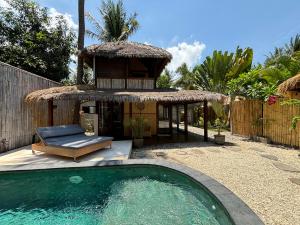 un complejo con piscina y cabaña en Villa Maiya, en Gili Air