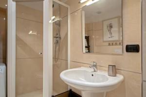 uma casa de banho branca com um lavatório e um chuveiro em Appartamento nuovo 6 posti - Abetone em Abetone