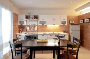 a kitchen with a table and chairs and a kitchen with a refrigerator at Appartamento Centralissimo - Abetone in Abetone