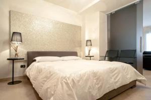 a bedroom with a large white bed with two lamps at Appartamento nuovo 6 posti - Abetone in Abetone