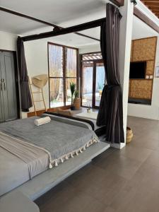 a bedroom with a bed and a large window at Villa Maiya in Gili Islands