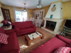 sala de estar con sofás rojos y chimenea en Chalet los sauces, en Cabo de Palos