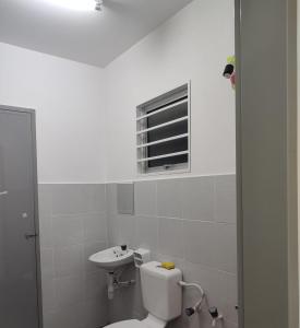 ein weißes Badezimmer mit Toilette und Waschbecken in der Unterkunft Umi Homestay, Laman Haris in Bandar Puncak Alam