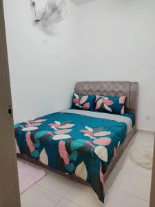 1 cama con edredón azul y almohadas en una habitación en Umi Homestay, Laman Haris, en Bandar Puncak Alam