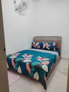 Bett mit blauer Bettdecke und Kissen in einem Zimmer in der Unterkunft Umi Homestay, Laman Haris in Bandar Puncak Alam + 4 Fotos