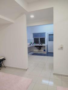 Habitación blanca con escritorio y mesa. en Umi Homestay, Laman Haris, en Bandar Puncak Alam