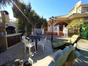 patio ze stołem i krzesłami oraz dom w obiekcie Chalet los sauces w mieście Cabo de Palos