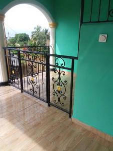 a balcony with a black railing and a green wall at NGOME Lounge 