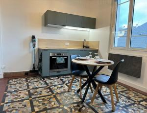 - une cuisine avec une table, deux chaises et une cuisinière dans l'établissement L'Escale, à Rennes