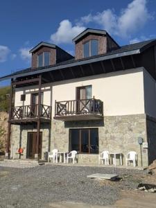 a large building with chairs and a balcony at Khando2023 in Gudauri