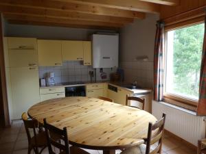 a kitchen with a wooden table and chairs in it at Chalet Beaujon Chapelle-des-Bois in Chapelle-des-Bois +21 photos