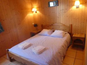 een slaapkamer met een bed met twee handdoeken erop bij Chalet Beaujon Chapelle-des-Bois in Chapelle-des-Bois