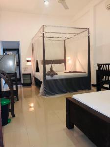 a bedroom with a bed with a mosquito net at Tinara River Inn, Weligama in Weligama