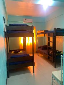 a room with three bunk beds in a room at Ahras Place in Coron