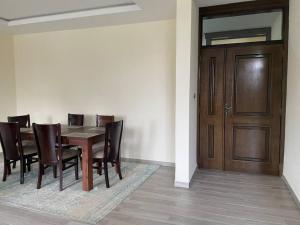 a dining room with a table and chairs and a wooden door at Modern living in Addis Ababa