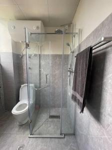a bathroom with a toilet and a glass shower at Modern living in Addis Ababa