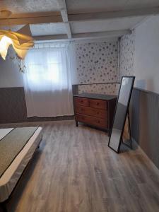 a bedroom with a bed and a dresser and a window at Smith Cosy in Châteaumeillant +11 photos