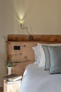 a bedroom with a white bed with a wooden headboard at Sporting Hotel San Felice in Illasi