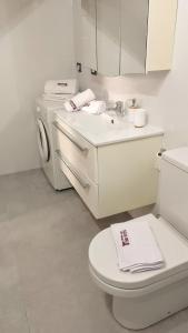 uma casa de banho branca com um lavatório e uma máquina de lavar roupa em sciuliddA Casa Vacanze em Avola