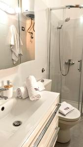 uma casa de banho branca com um chuveiro e um lavatório. em sciuliddA Casa Vacanze em Avola