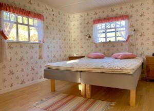 Un dormitorio con una cama con almohadas rosas. en Flemma Gård By the lake en Vreta Kloster