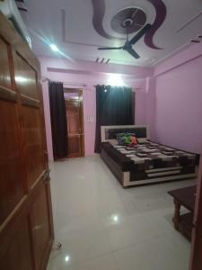 Schlafzimmer mit einem Bett und einem Deckenventilator in der Unterkunft Divine INN hotel and guest house in Bamrauli