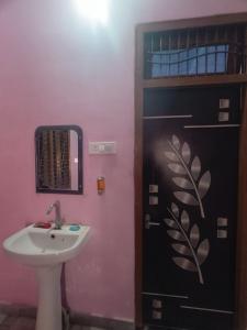 a bathroom with a sink and a door at Divine INN hotel and guest house in Bamrauli