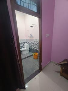 eine Tür zu einem Bad mit WC in einem Zimmer in der Unterkunft Divine INN hotel and guest house in Bamrauli