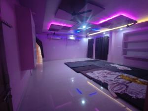 una camera con luci viola e un letto interno di Divine INN hotel and guest house a Bamrauli