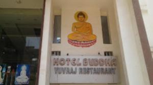 un cartel en un edificio con una mujer sentada en una olla de kritkritkrit en Hotel Buddha,Gaya en Bodh Gaya