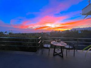 a table and chairs on a balcony with a sunset at Marbella Boutique Art suites in Marbella