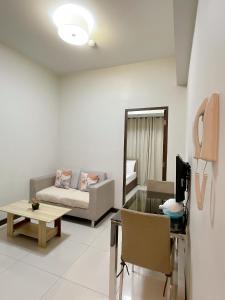 a living room with a couch and a table at Admiral Baysuites 1 BR Unit in Manila