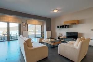 a living room with two couches and a tv at Malena in Karavomylos