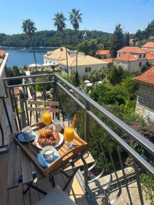a table with a plate of food on a balcony at Apartments Villa Agava in Cavtat